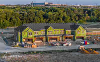 Drone view of a construction project showing building progress, site organization, and surrounding development.